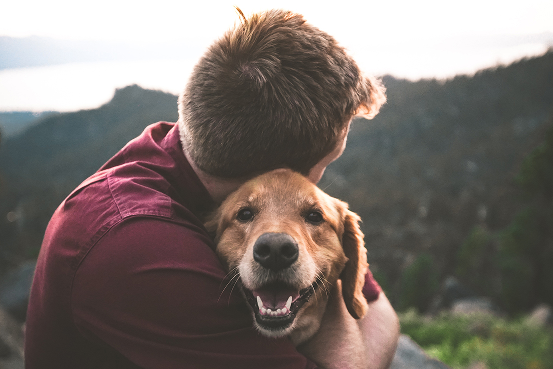 Imagen de un hombre abrazando a un perro