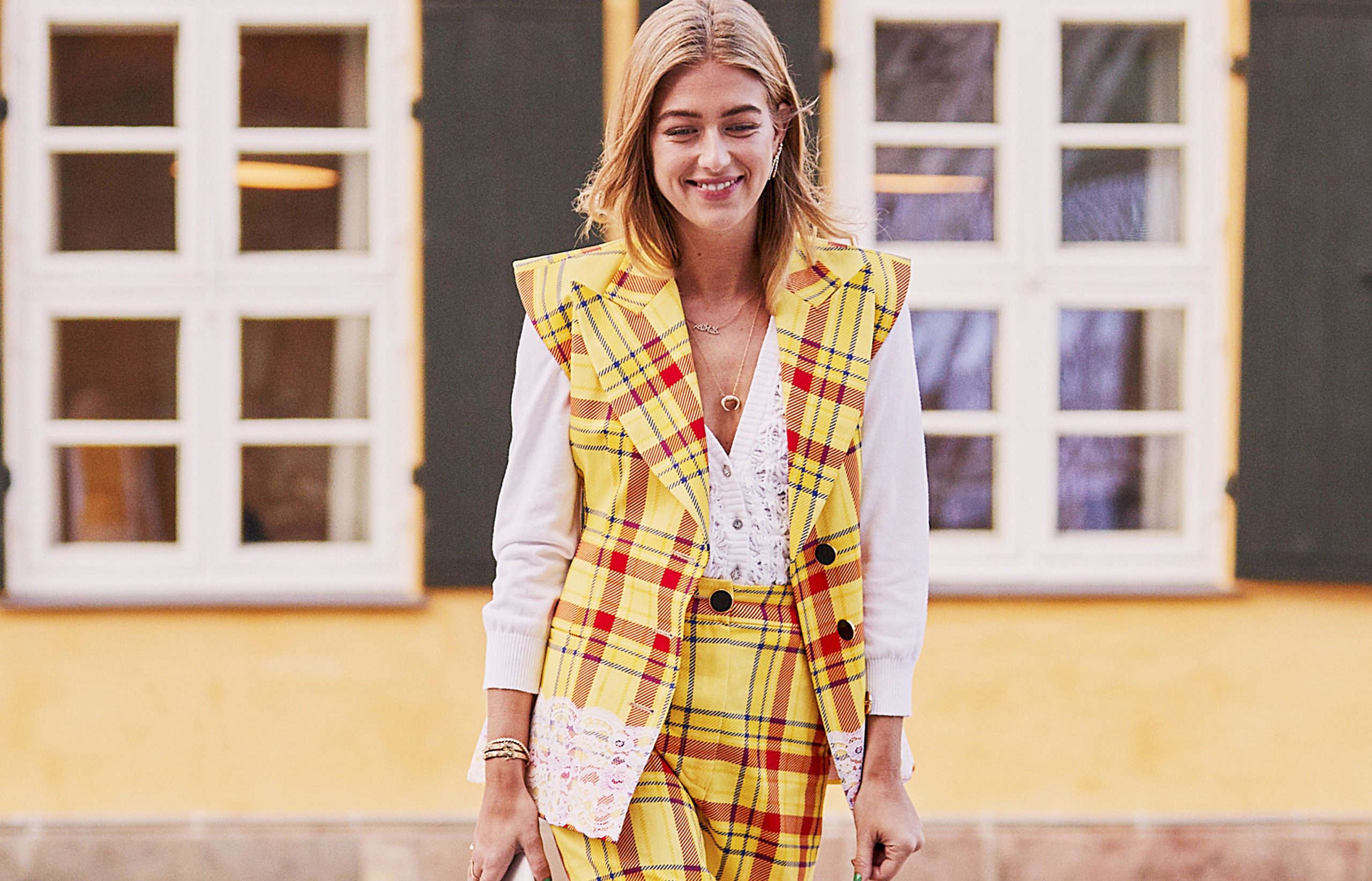 Imagen de una mujer joven, en la calle, vestida con un traje pantalón de cuadros