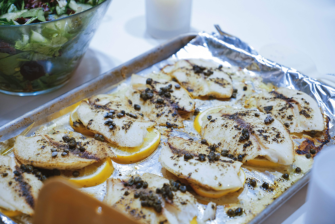 imagen de una bandeja con pescado patatas o limon en una base de papel de aluminio