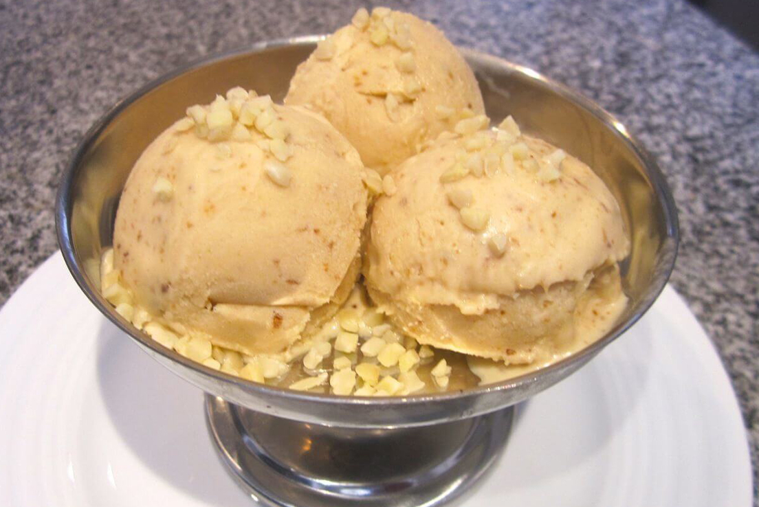 imagen de tres bolas de helado de turrón sobre una vaso de aluminio